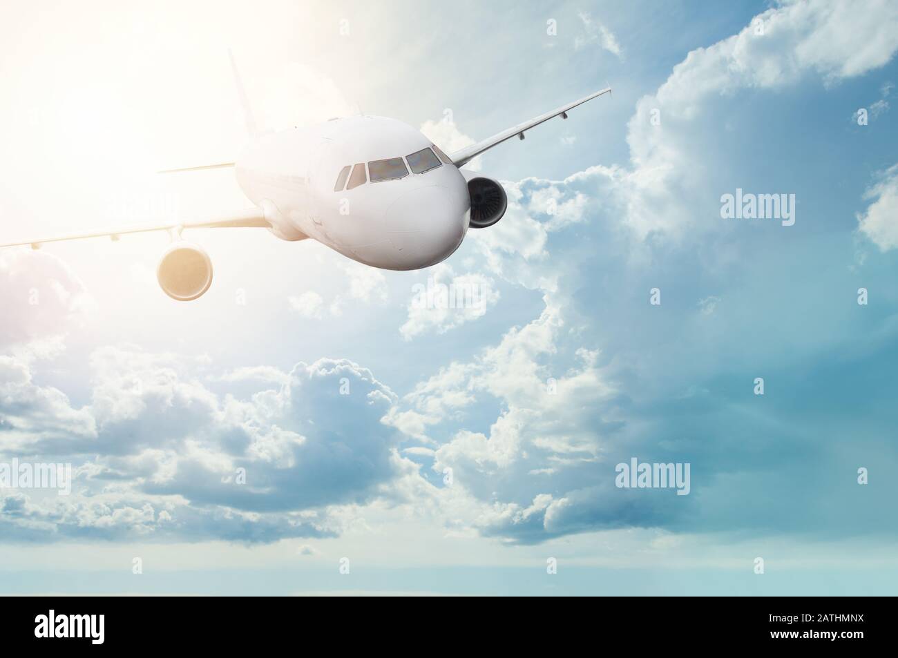 White plane flying in the sky with clouds Stock Photo - Alamy