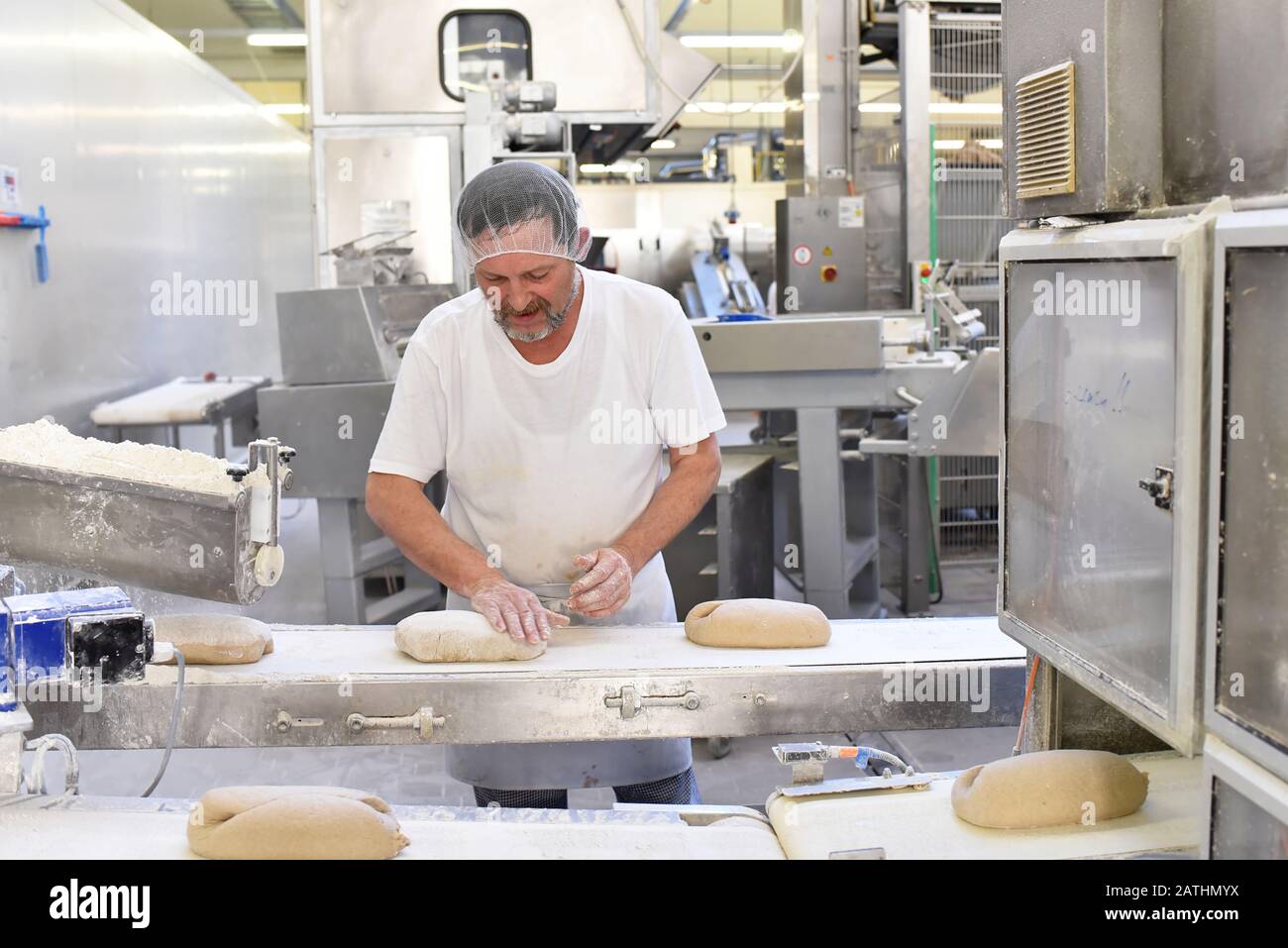 Worker in a large bakery industrial production of bakery products on