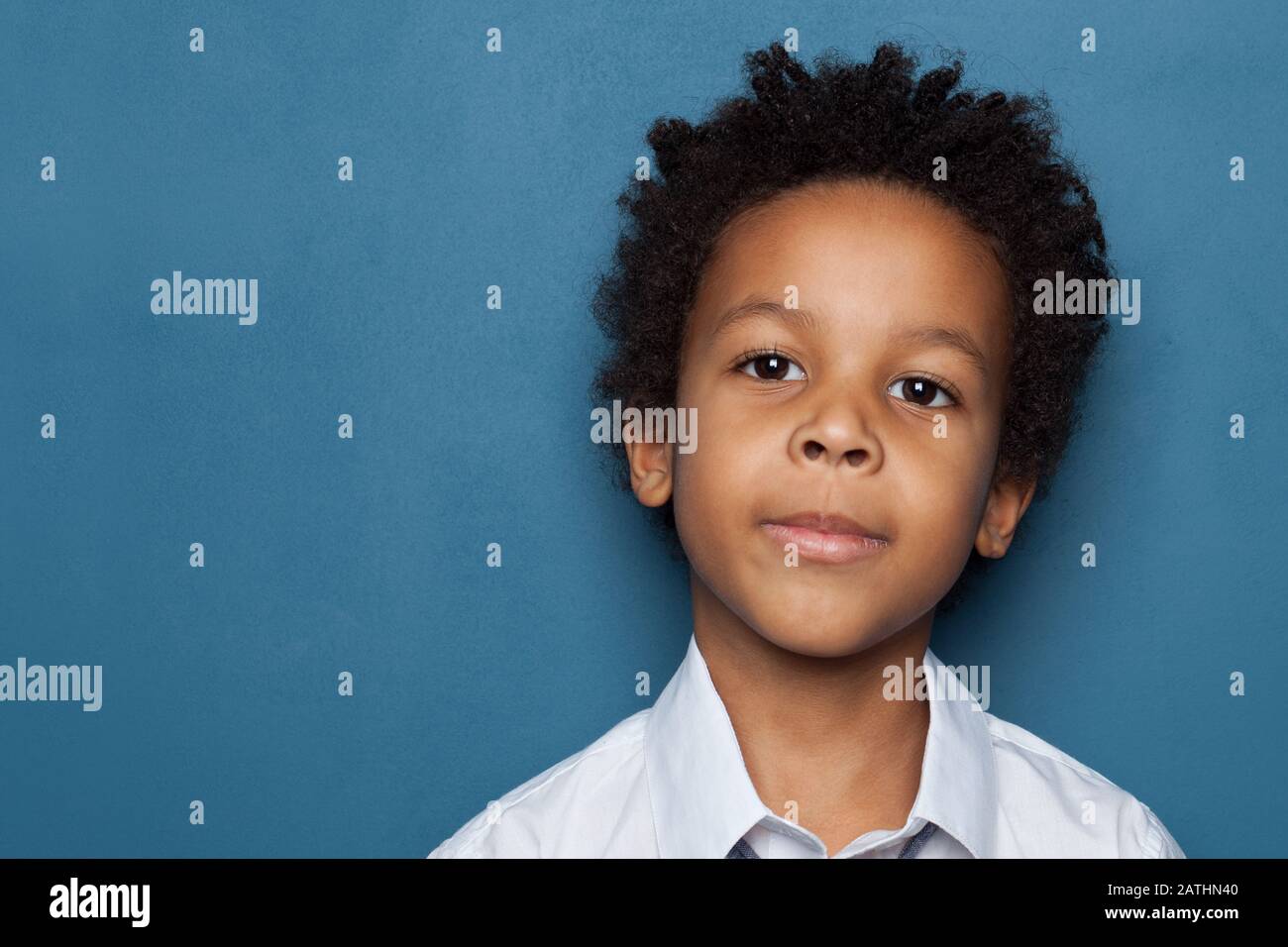 Curious African American child boy on blue background Stock Photo