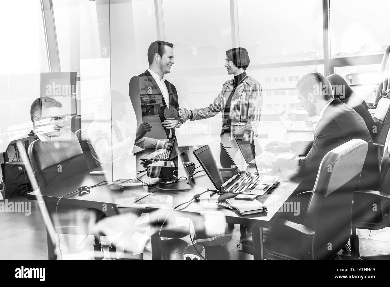 Confident business people shaking hands in moder corporate office. Stock Photo