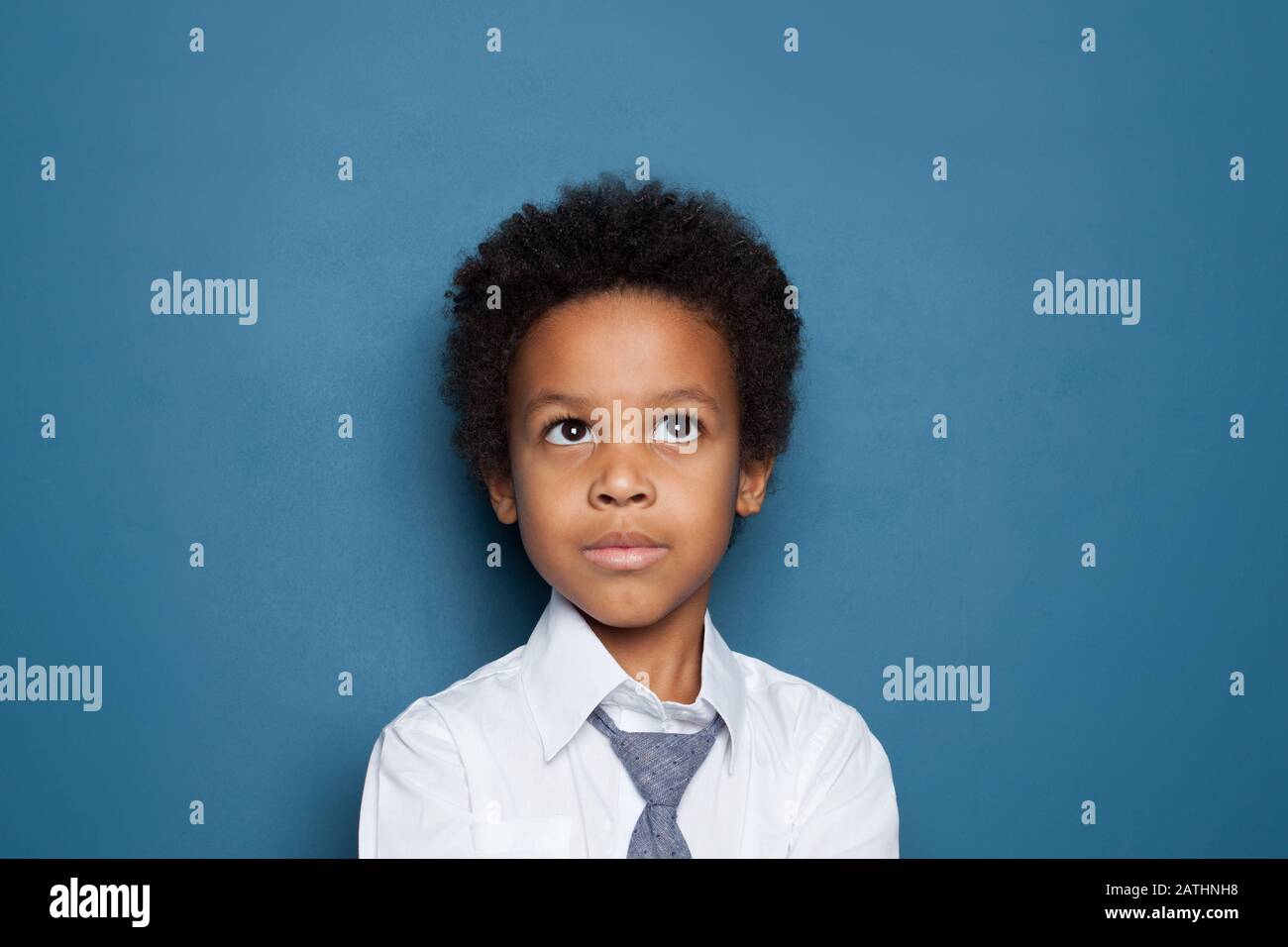 African American kid school boy pupil 6 years old on blue backgroung portrait Stock Photo