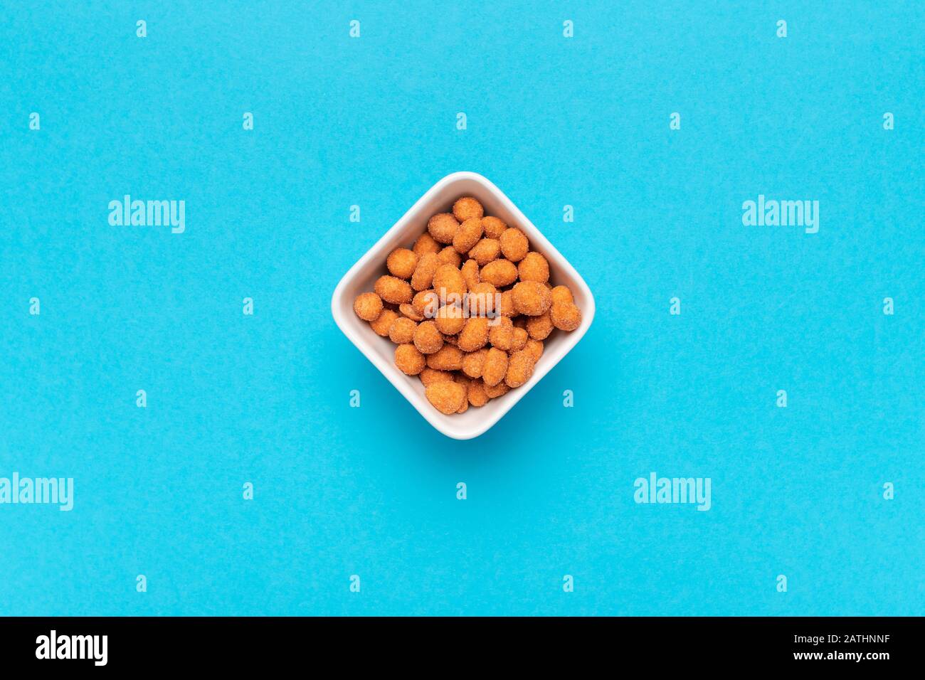 Salty peanut snack coated with barbecue sauce layer, flat lay top view with copy space Stock Photo
