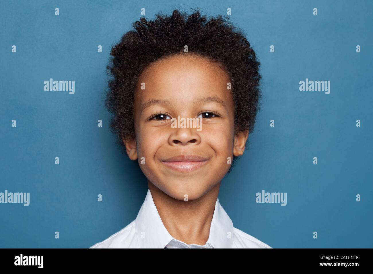Happy African American Child Boy Smiling on Blue Background. Close up Kid Face Stock Photo