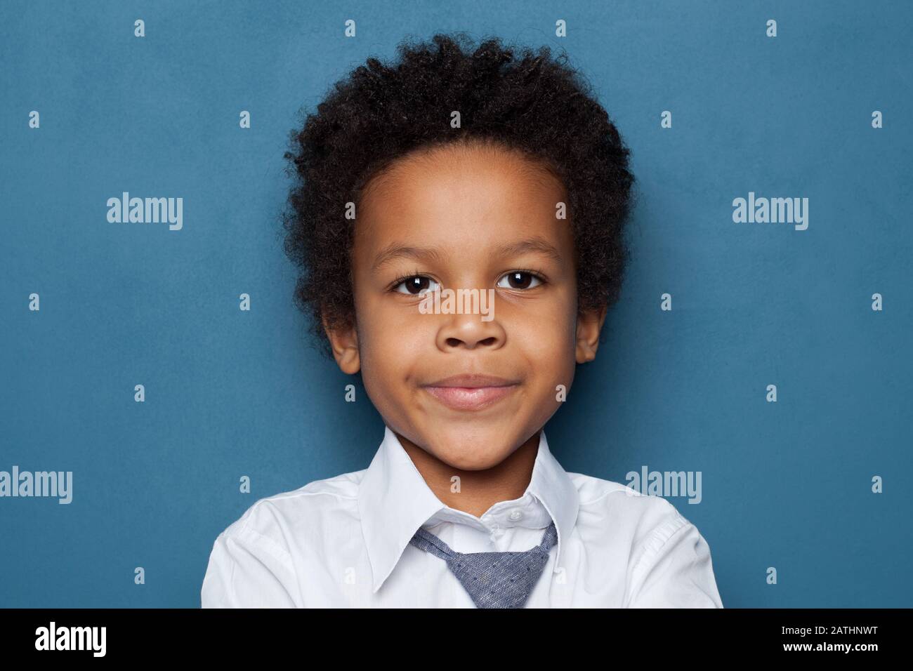 Curious black child schoolboy student portrait on blue background Stock Photo