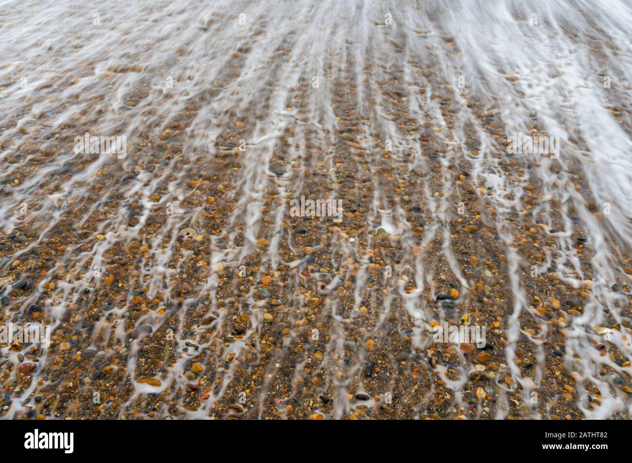 Waves washing across the shingle of Collywell Bay near Seaton Sluice, Northumberland, England Stock Photo