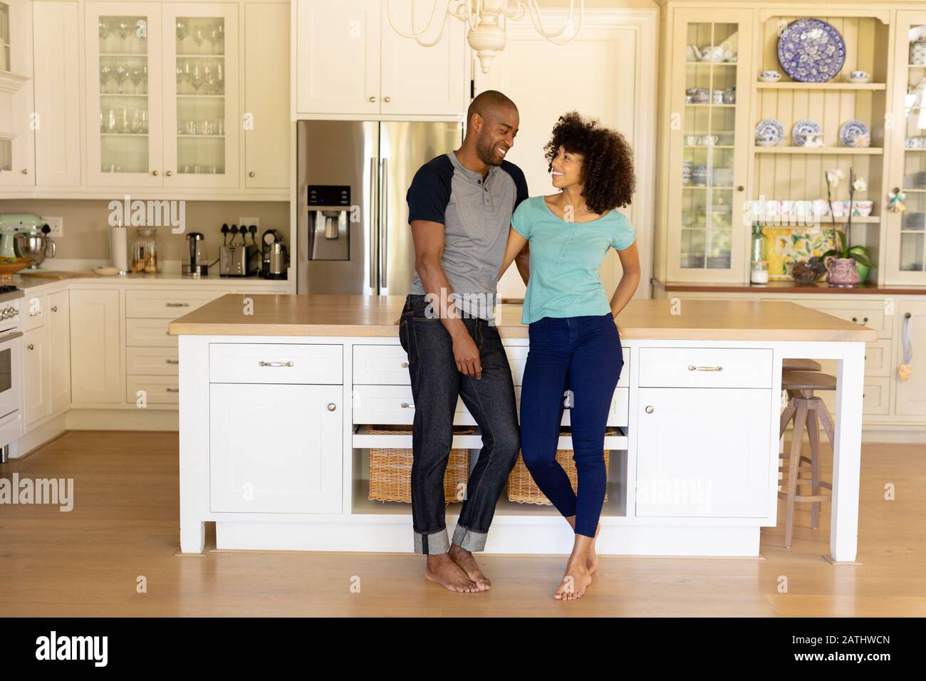 Happy young couple standing in the kitchen Stock Photo