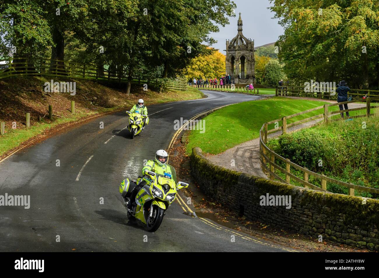 2 male paramedics riding, travelling on motorbikes (ambulance bikes) - rapid response vehicles on call (country lane, Bolton Abbey, Yorkshire, GB, UK) Stock Photo