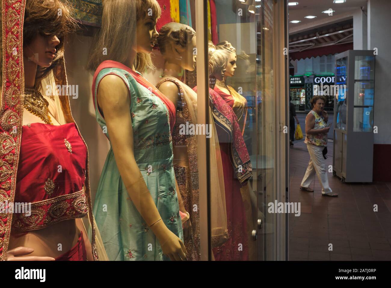 A foreign tourist passes by a shop selling Indian traditional attire; Little India area, Singapore Stock Photo