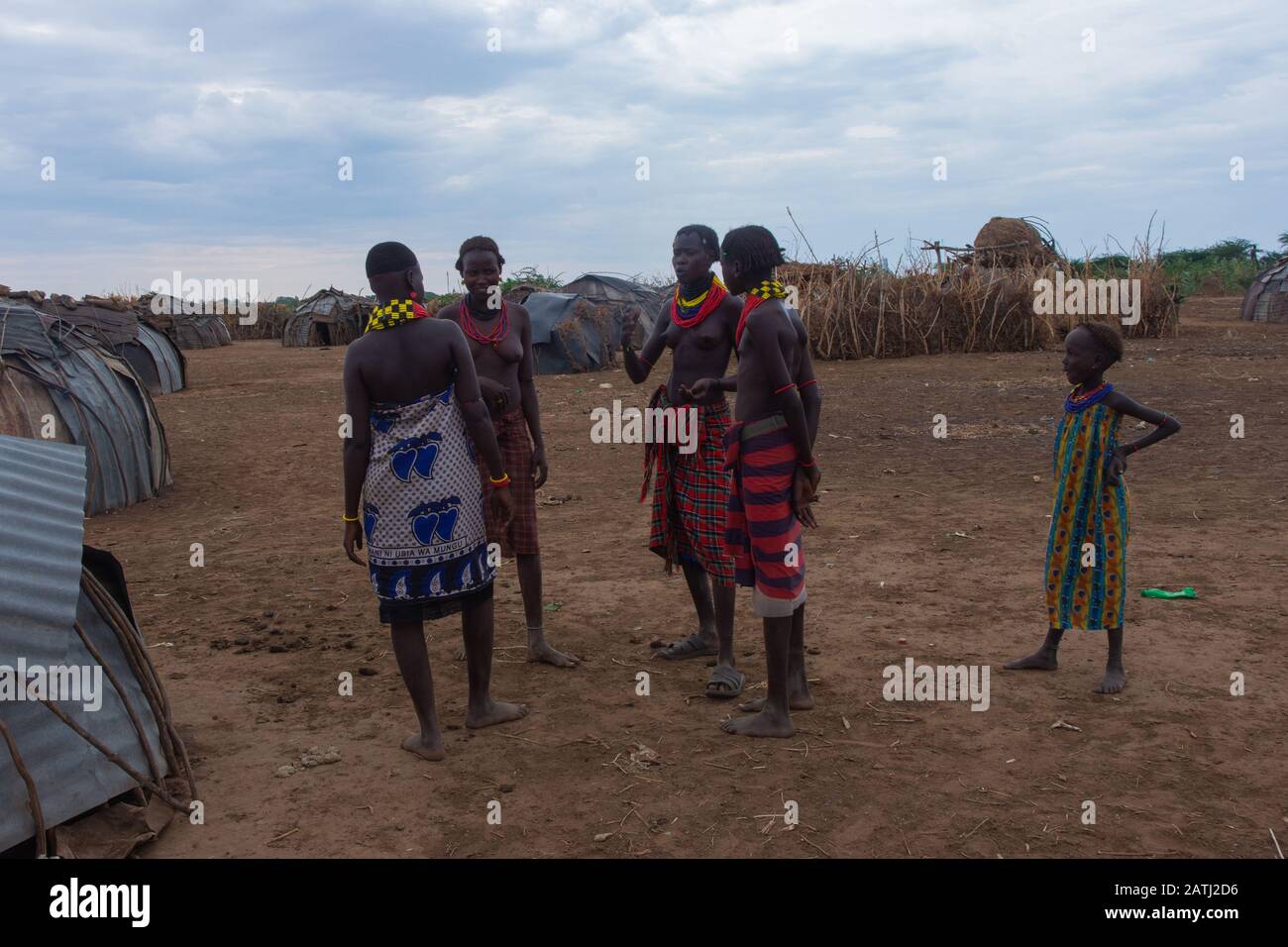 Omorate, Ethiopia - Nov 2018: Young men and women wearing traditional tribal clothes and necklaces talking with each other. Omo valley Stock Photo