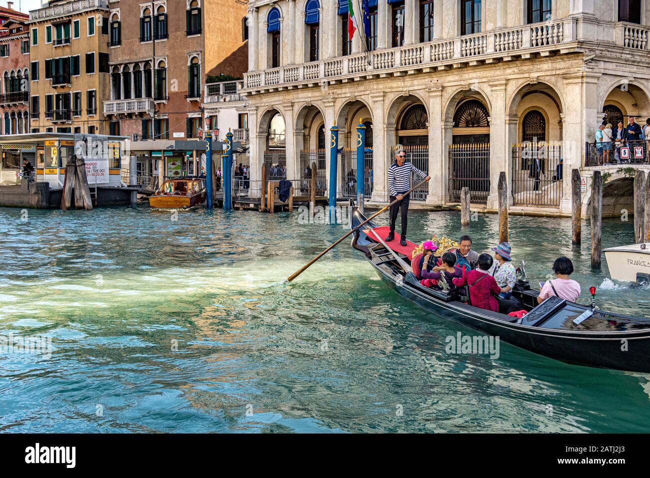 A gondolier taking Chinese tourists for a gondola ride past the Ca' d'Oro a Gothic palace ,along The Grand Canal ,Venice ,Italy Stock Photo
