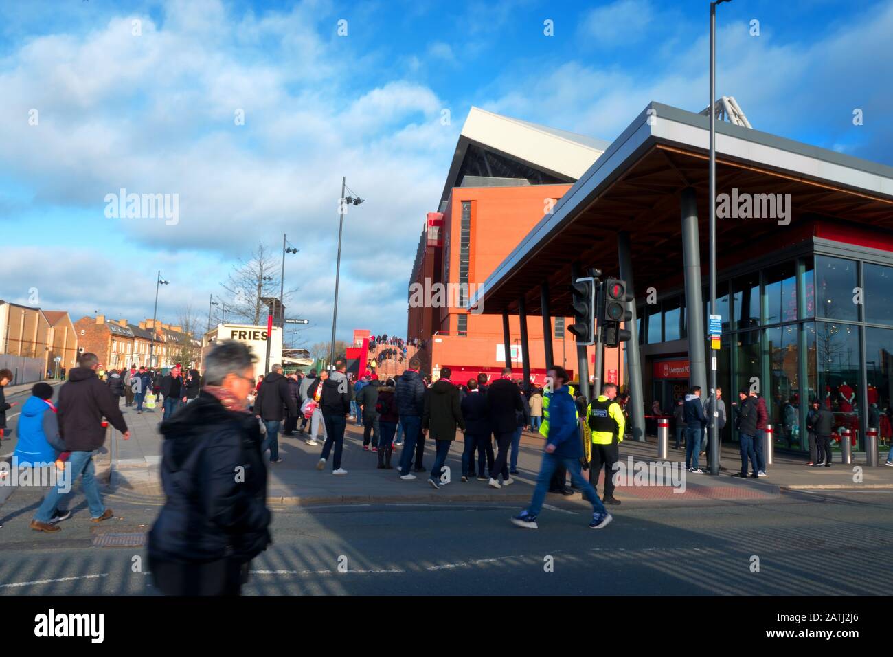 Liverpool supporters going to the match with the new club shop and main stand in the background. Stock Photo