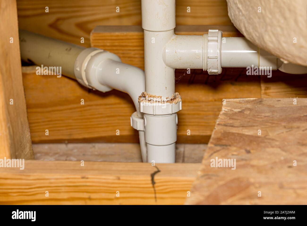 Old leaking plastic plumbing drain pipes under floor for bathroom tub and shower. Concept of DYI home maintenance, repair, remodeling Stock Photo