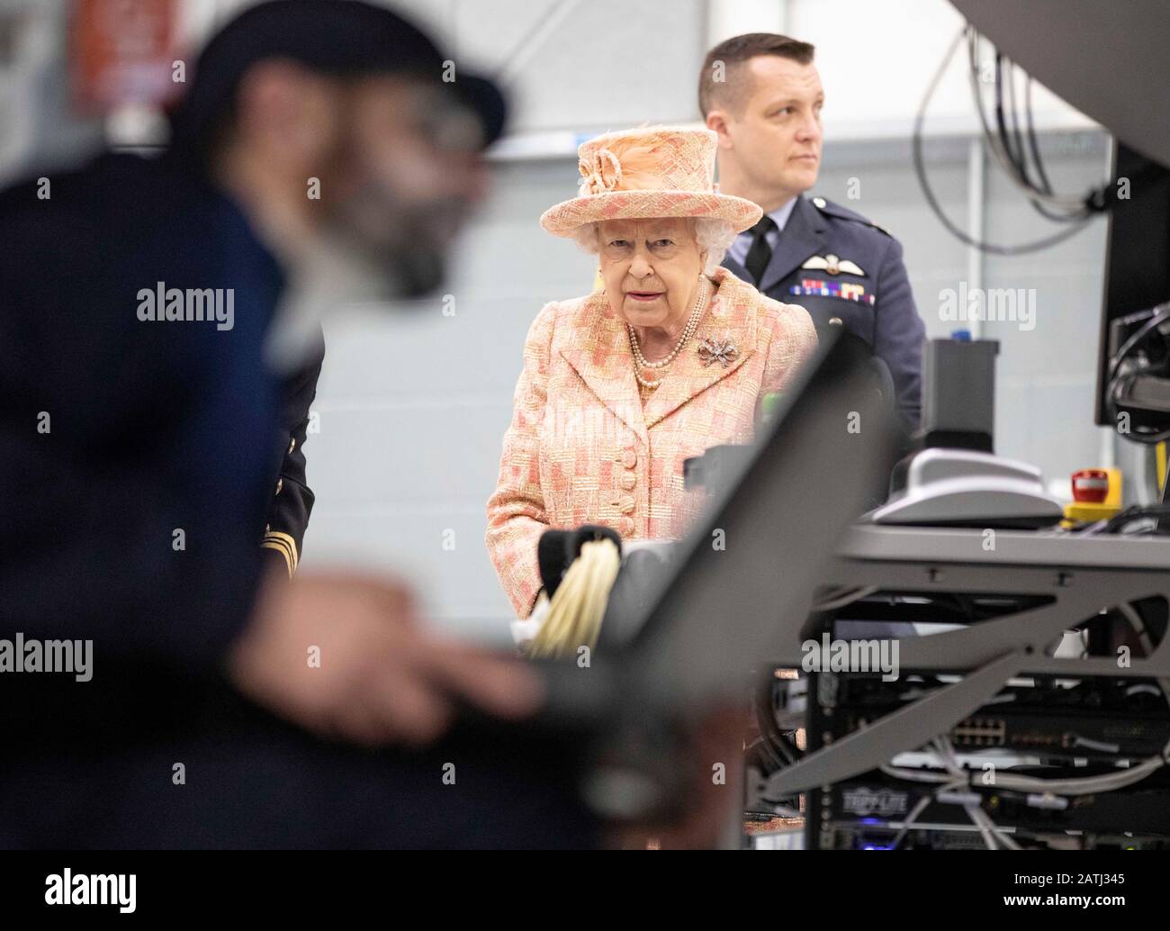 Queen Elizabeth II, with Station commander Group captain James Beck (right), watches air crew at work on a training model F-35B Lightning II fighter during a visit to Royal Air Force Marham, Norfolk. Stock Photo