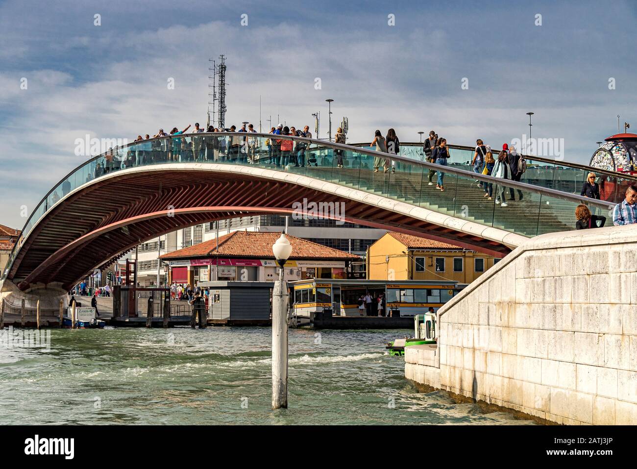 People walking across The Ponte delle Costituzione or Constitution Bridge in Venice , a glass and steel bridge which crosses The Grand Canal ,Venice Stock Photo