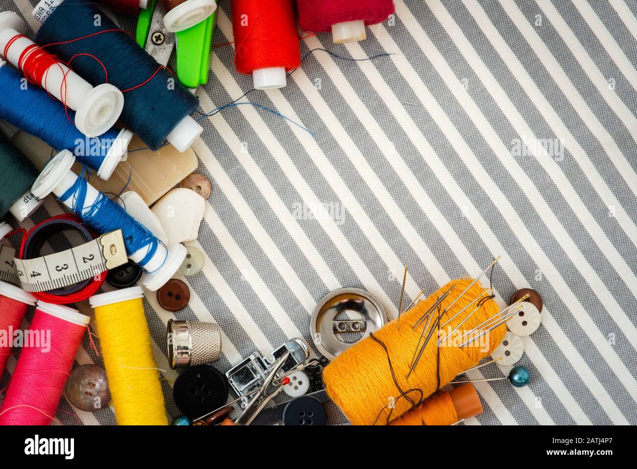 Sewing tools on striped background top view Stock Photo