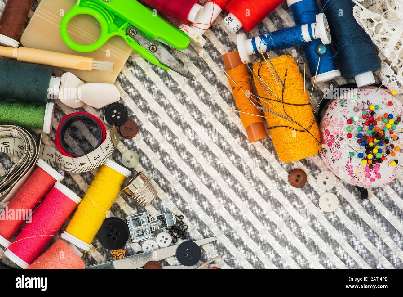 Sewing tools on striped background top view Stock Photo