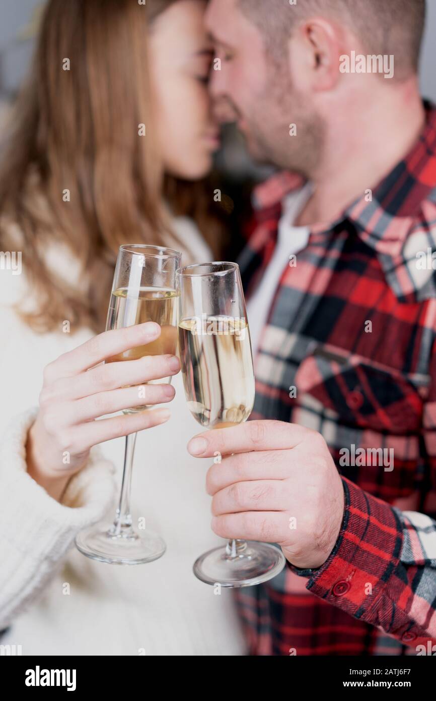 Selective focus of couple with glasses of champagne kissing in