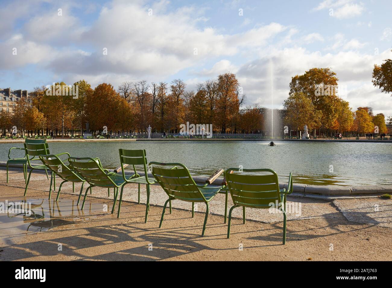PARIS - NOVEMBER 7, 2019: Tuileries garden with empty metal chairs and fountain in a sunny autumn day in Paris Stock Photo