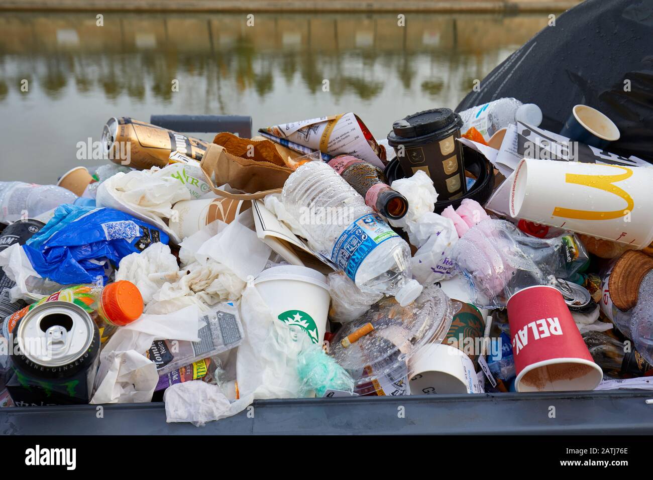 PARIS - NOVEMBER 8, 2019: Full garbage basket with colorful rubbish in Paris Stock Photo