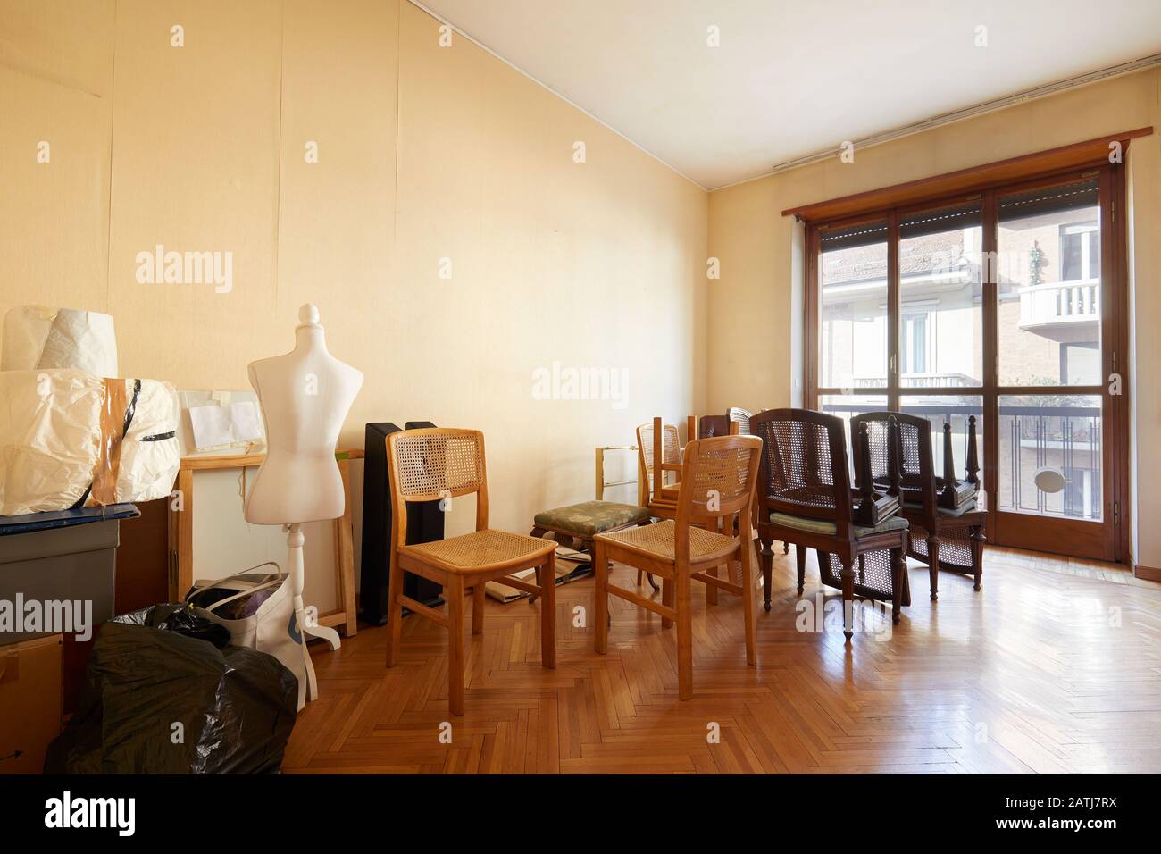 Room with chairs, boxes and a tailor dummy before moving house Stock Photo