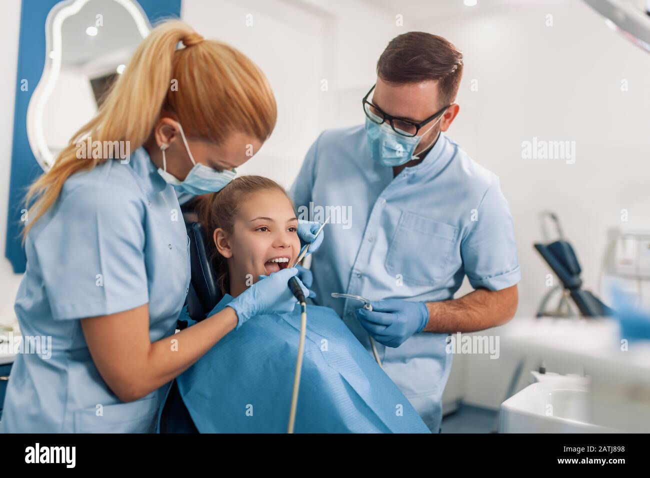 Children's dentist examination girls teeth, while she sitting on the dental chair at the office