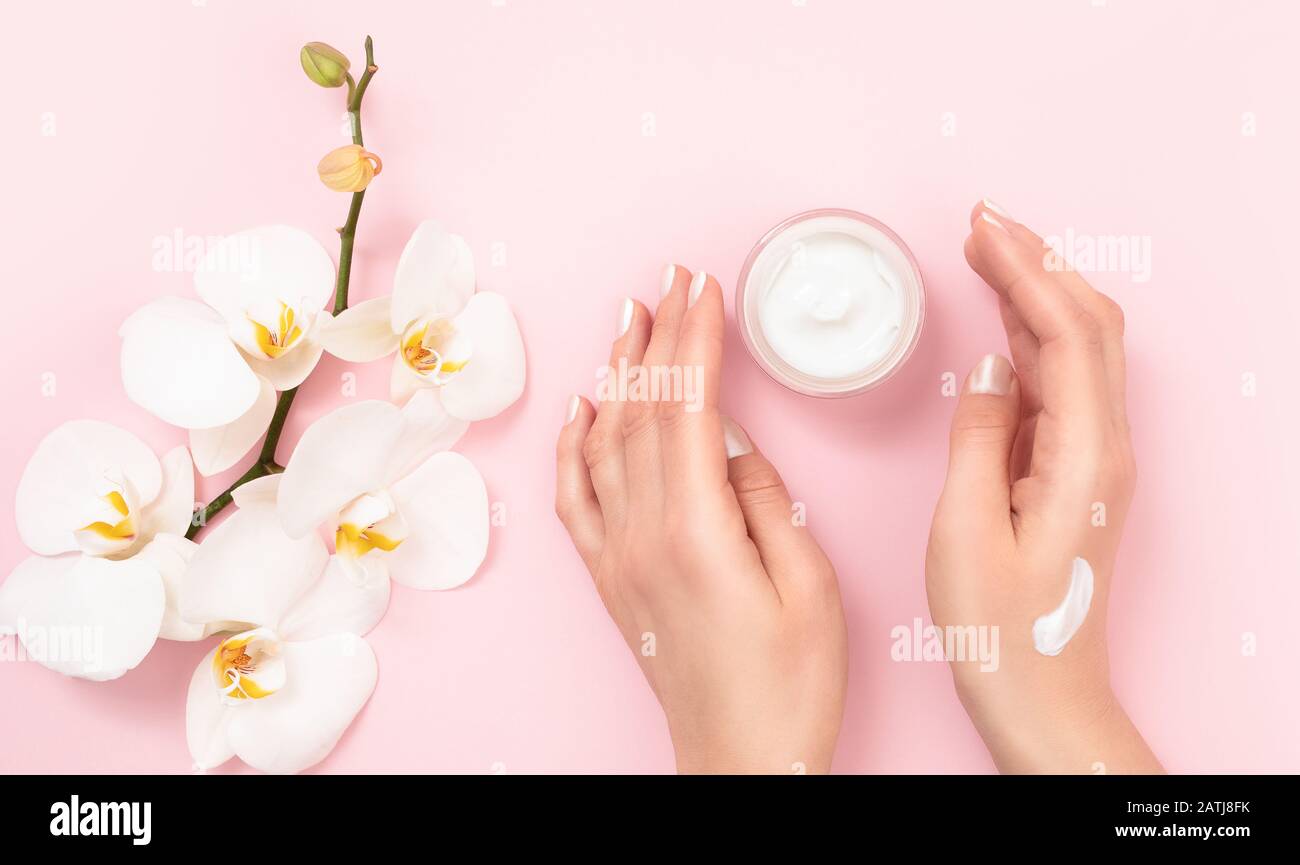 Woman applying moisturizing cream on hands. Cosmetic cream lotion concept. Stock Photo