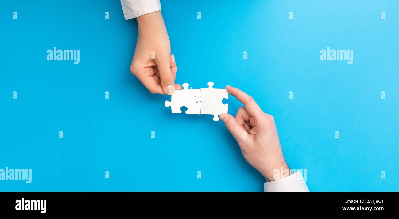 The man and woman holds in hand a jigsaw puzzle. Business solutions, success and strategy concept. Stock Photo
