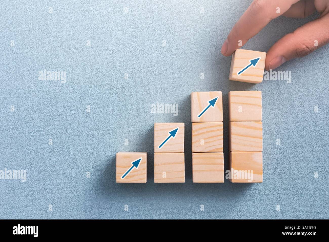 Hand arranging wood block with arrow up icon. Business concept growth success process. Stock Photo