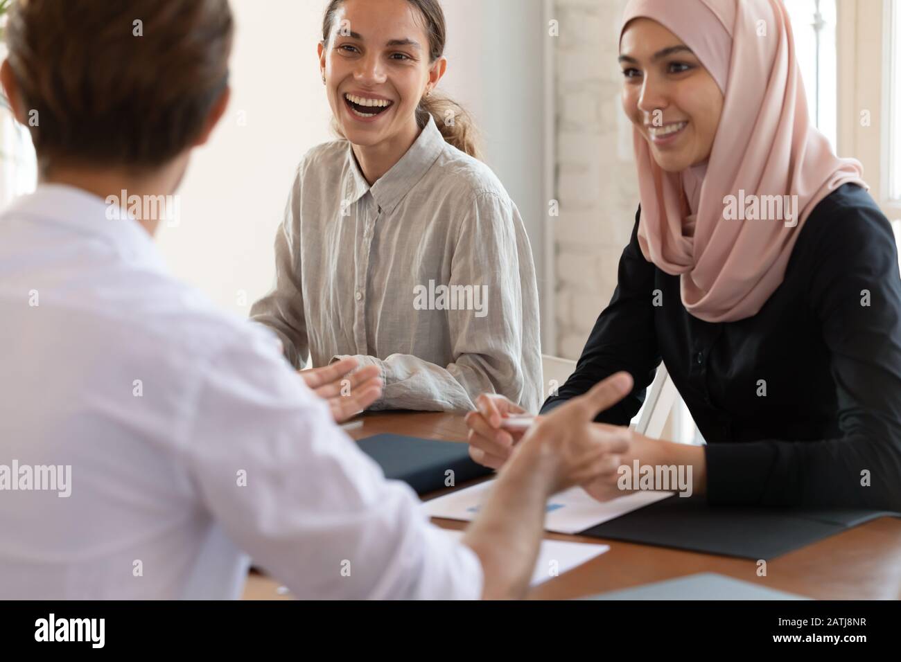 Happy multiracial employees laugh discussing ideas at meeting Stock ...