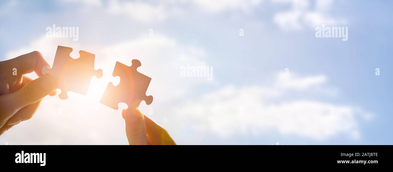 The man holds in his hand a jigsaw puzzle. Business solutions, success and strategy concept. Stock Photo