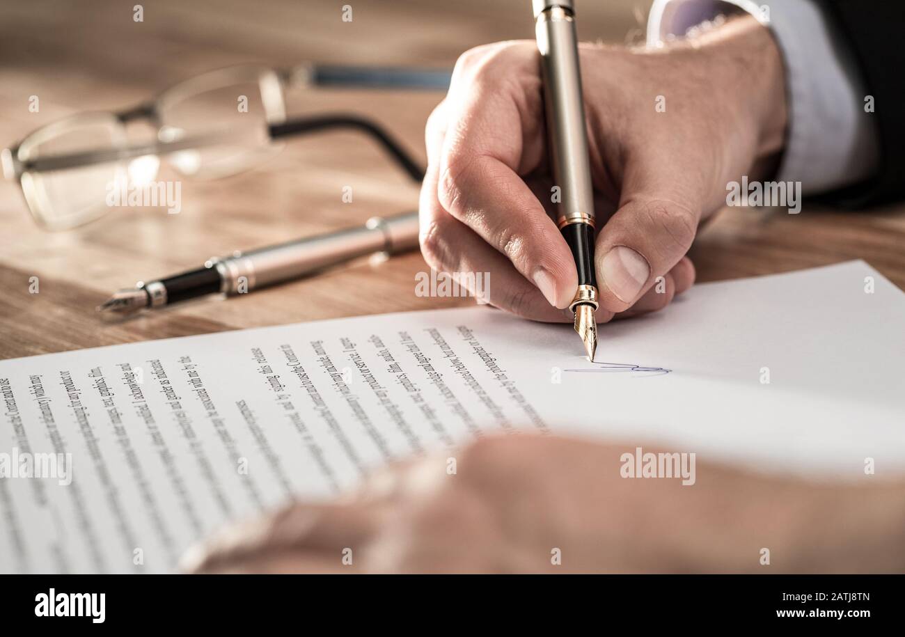 Business man signing contract document on office desk, making a deal. Stock Photo