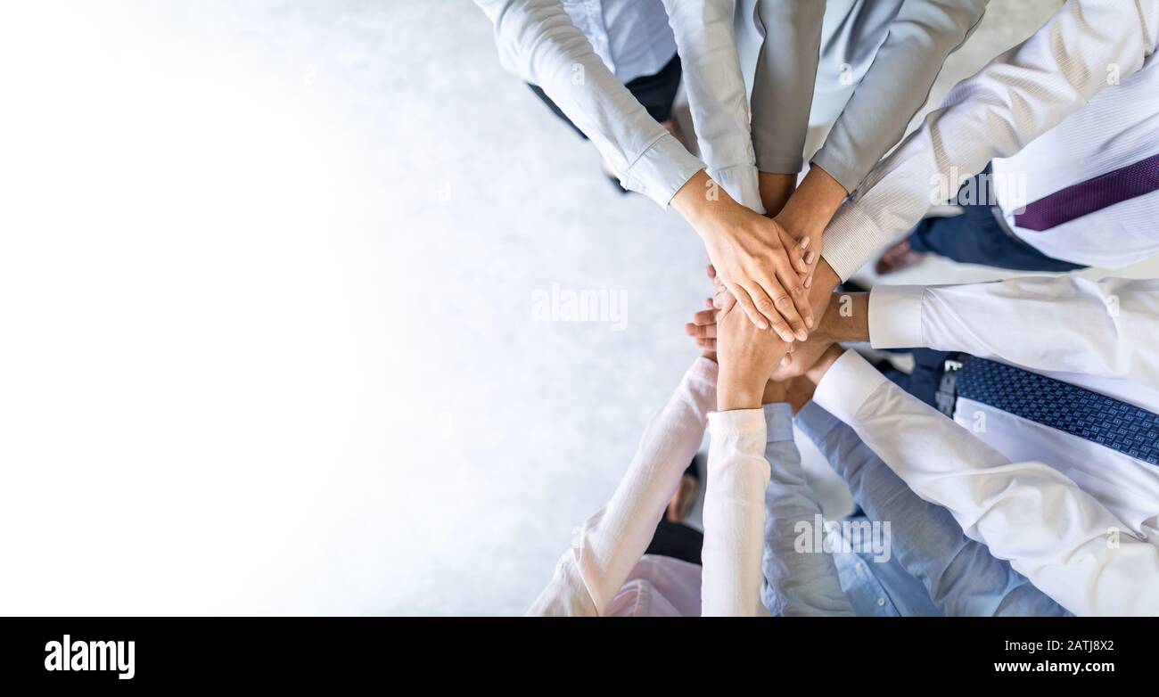 Close up top view of young business people putting their hands together. Stack of hands. Unity and teamwork concept. Stock Photo