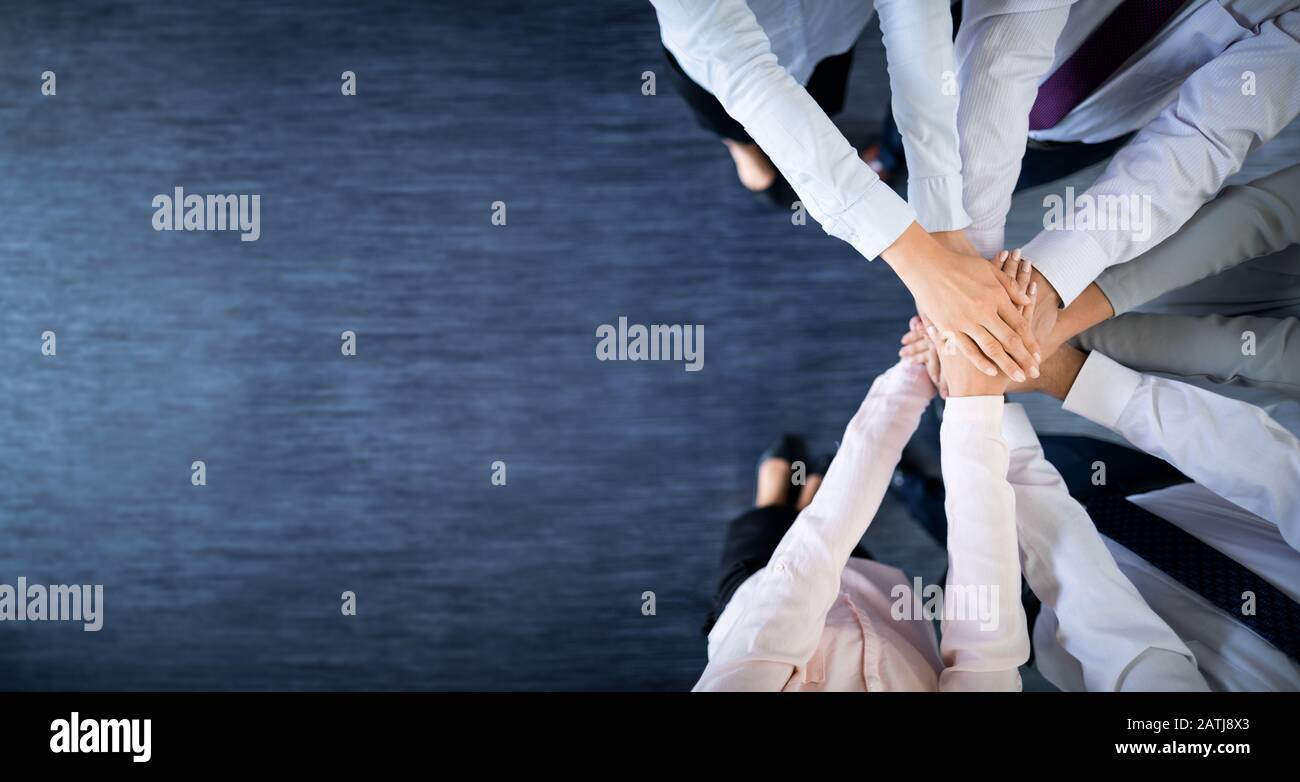 Close up top view of young business people putting their hands together. Stack of hands. Unity and teamwork concept. Stock Photo