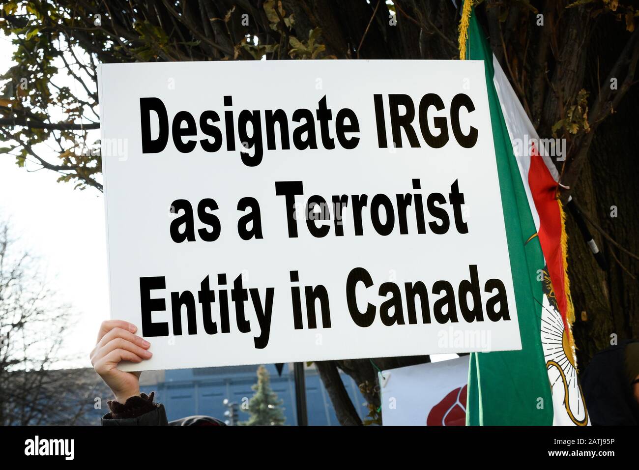 A demonstrator in solidarity with the protesters in Iran calls for Iran's Islamic Revolutionary Guard Corps to be listed as a terrorist entity. Stock Photo