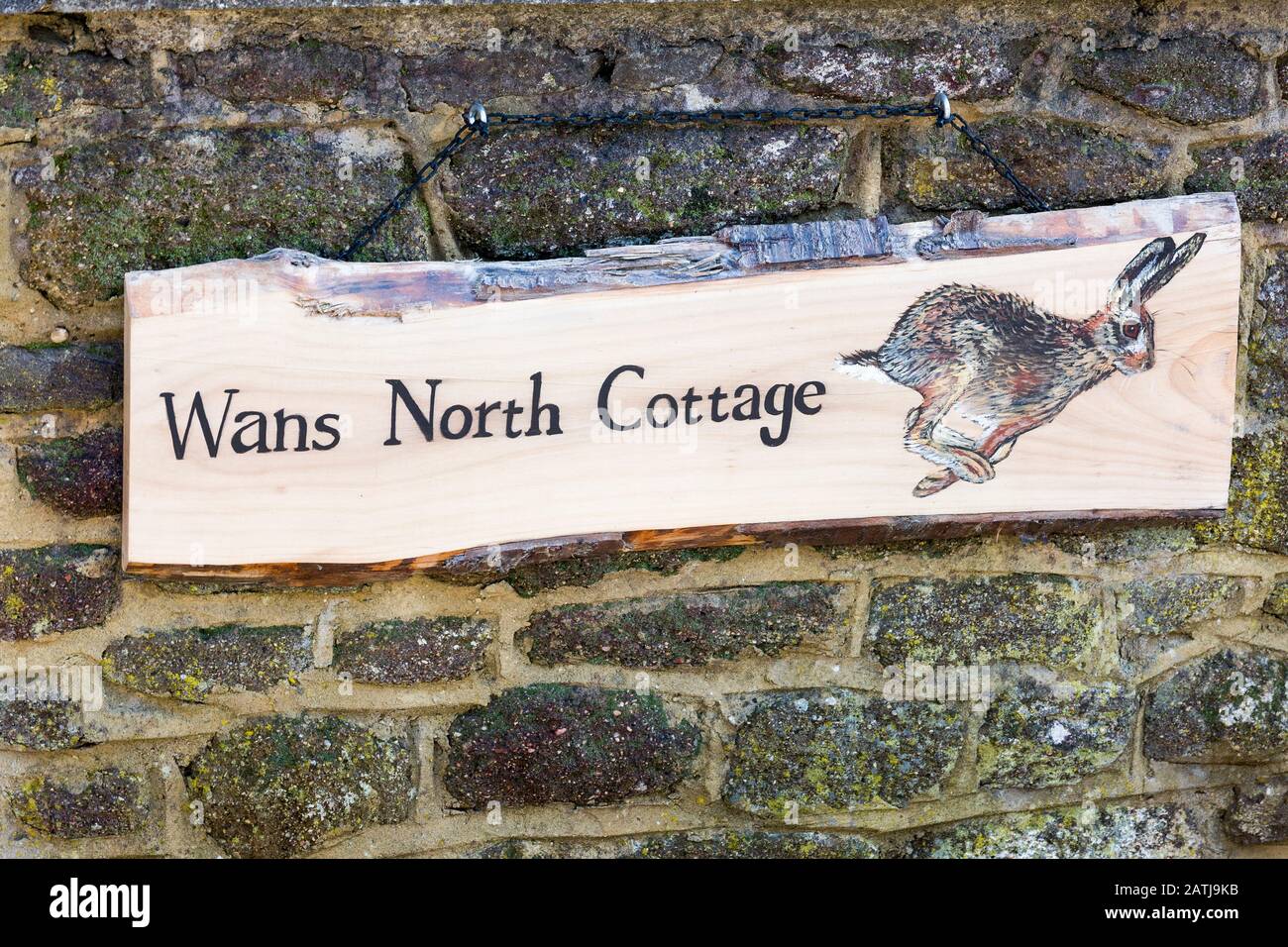 An unique house name-plate for Wans North Cottage on a stone garden wall in Sandy Lane village near Chippenham Wiltshire England UK Stock Photo