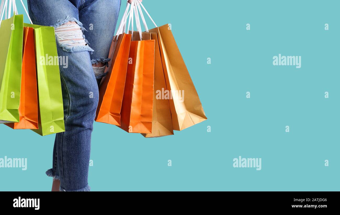 Shopping bags on women hands on the pastel isolated background Stock Photo