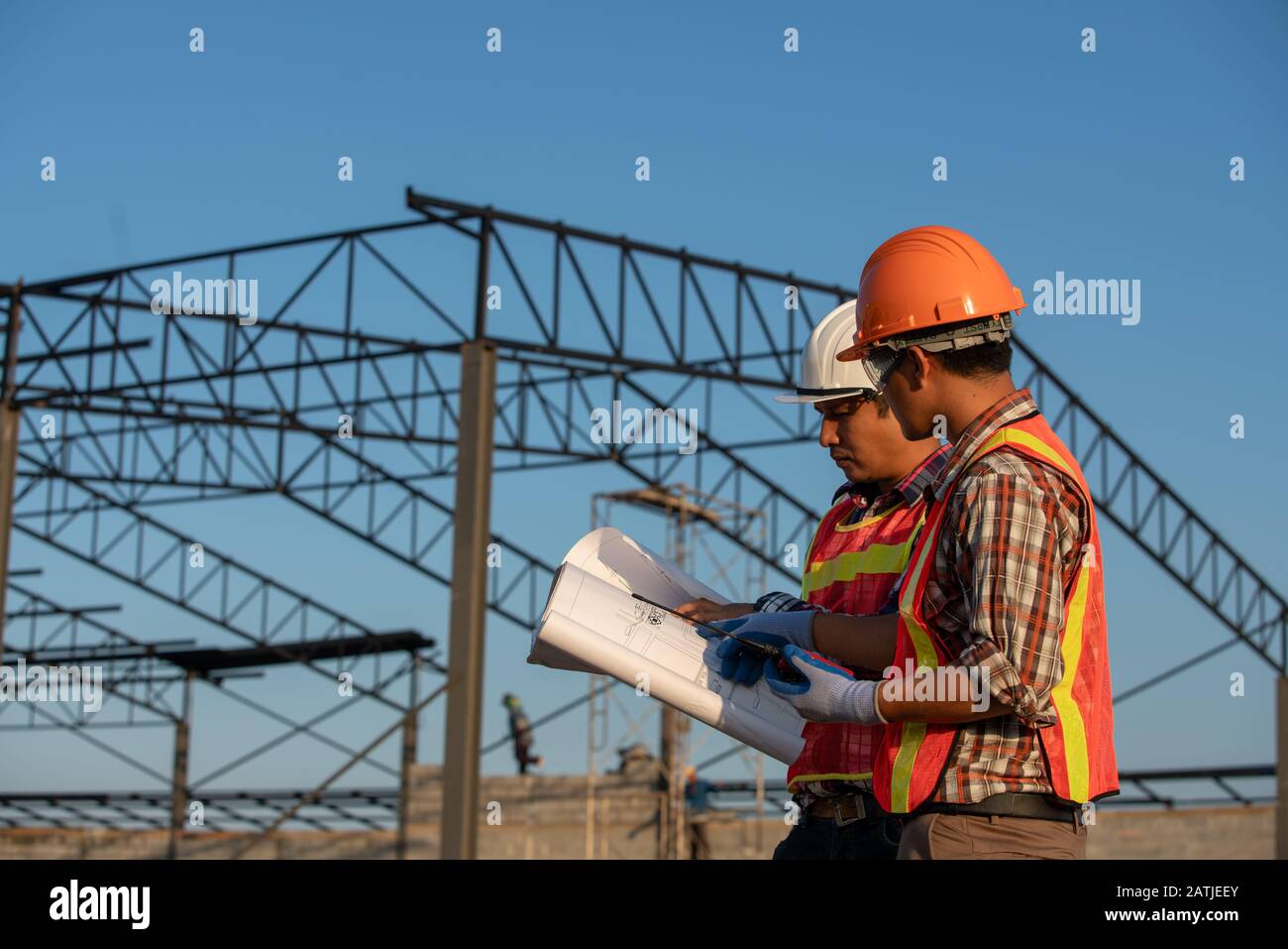 Construction work, Two engineers use blueprint analysis construction at the construction site Stock Photo