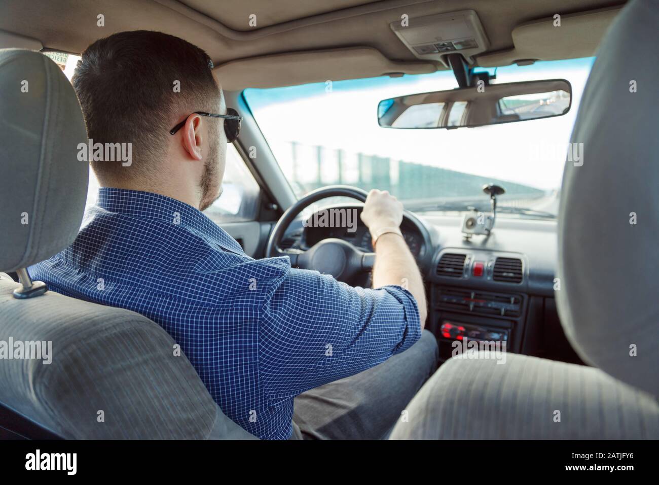 Back view of young man driving car Stock Photo Alamy