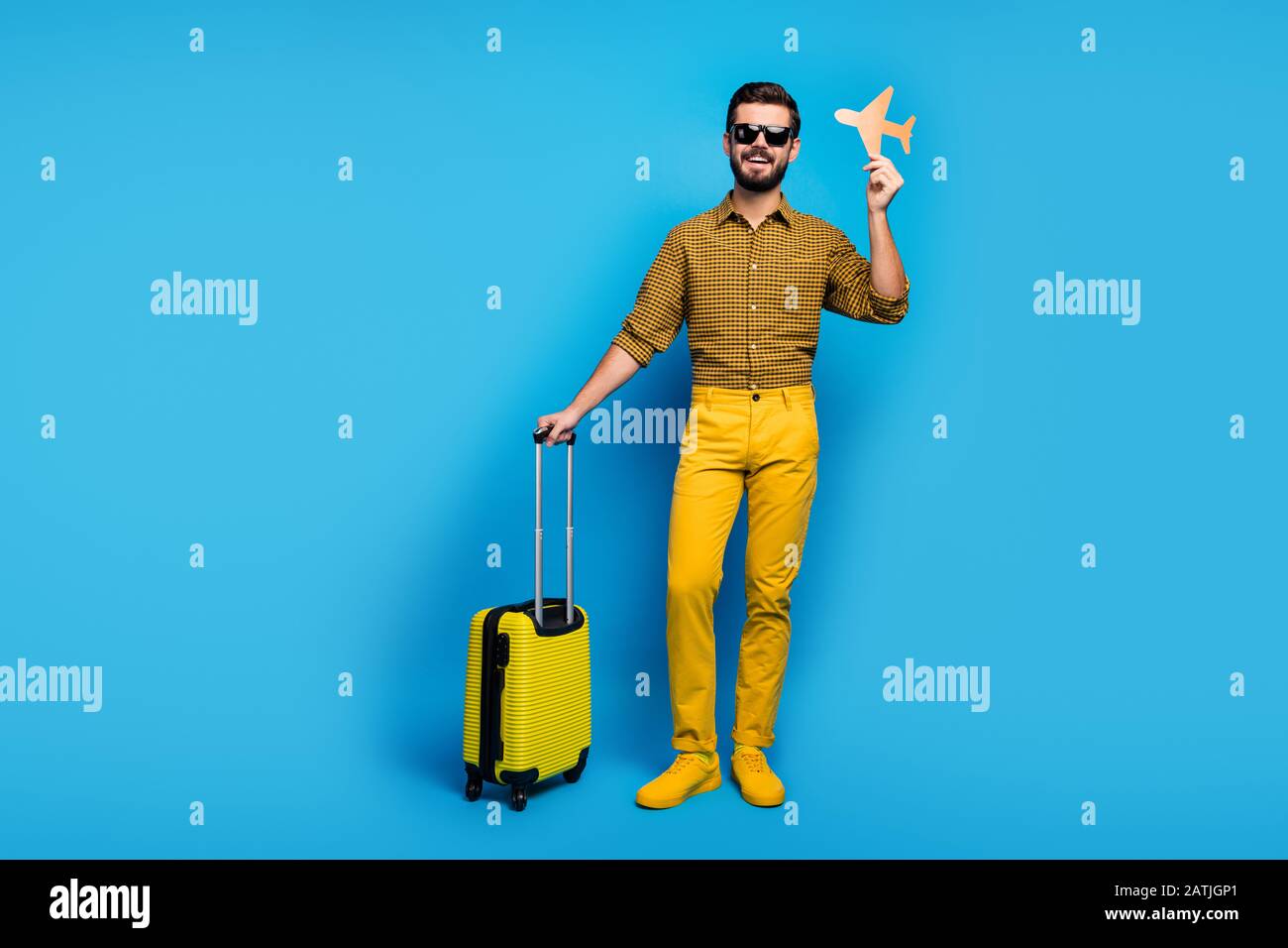 Full body photo positive bearded man enjoy tourism weekends hold orange papercard plane trolley travel air first-class wear checkered outfit bright Stock Photo