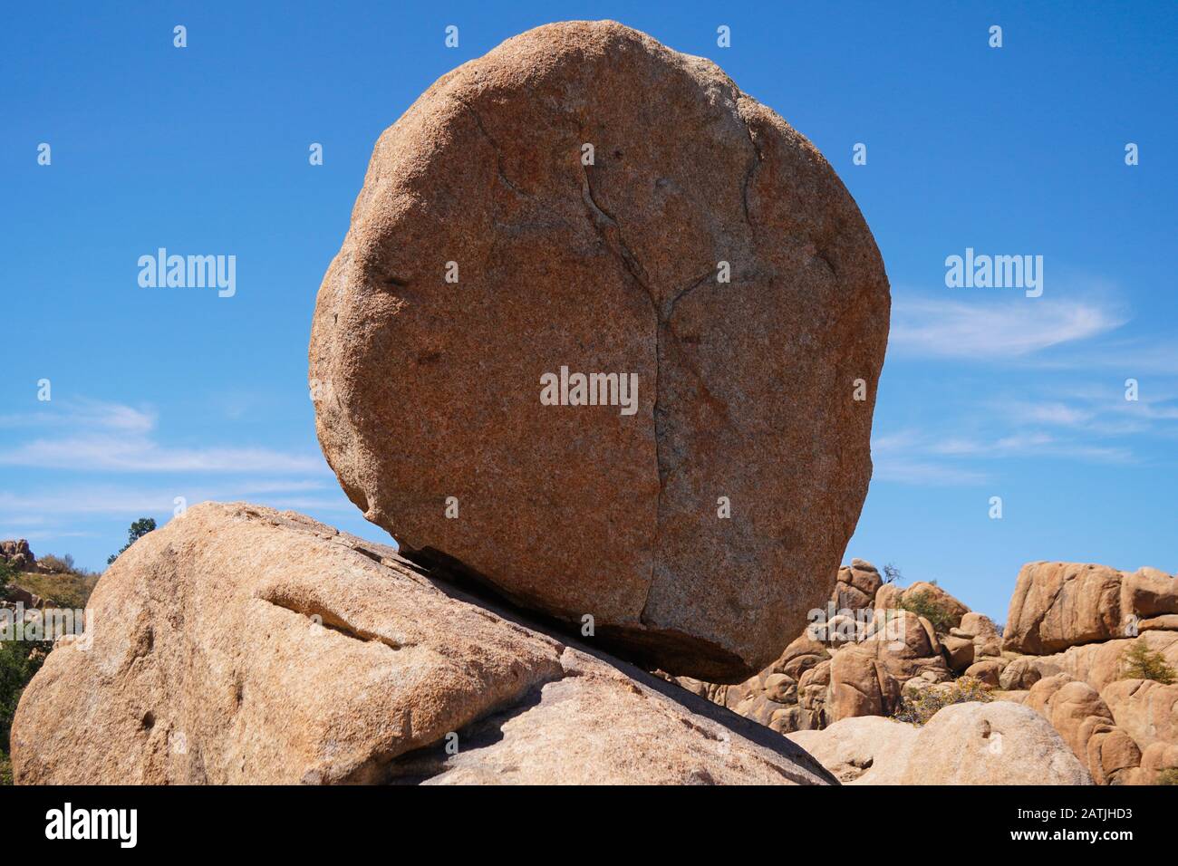 A Large granite boulder defying gravity clings precariously to the rocks below. Stock Photo