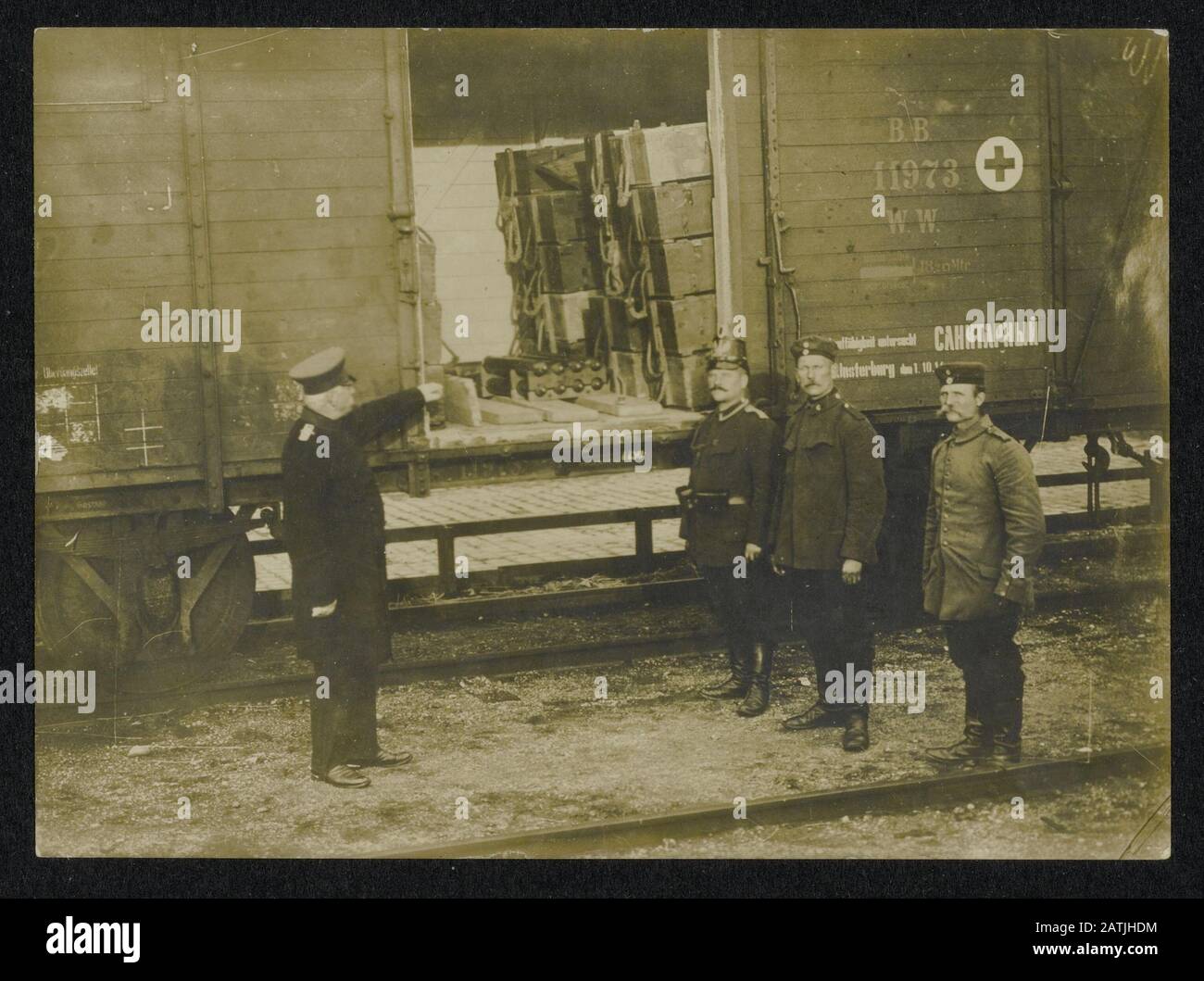 Description: Soldiers at a German train carrying Russian markings also Annotation: Railway wagon containing ammunition boxes. On the side is Red Cross sign to see. The man left in the row is a policeman. The man on the far left seems a railway employee Date: {1914-1918} Keywords: WWI, military, railway Stock Photo