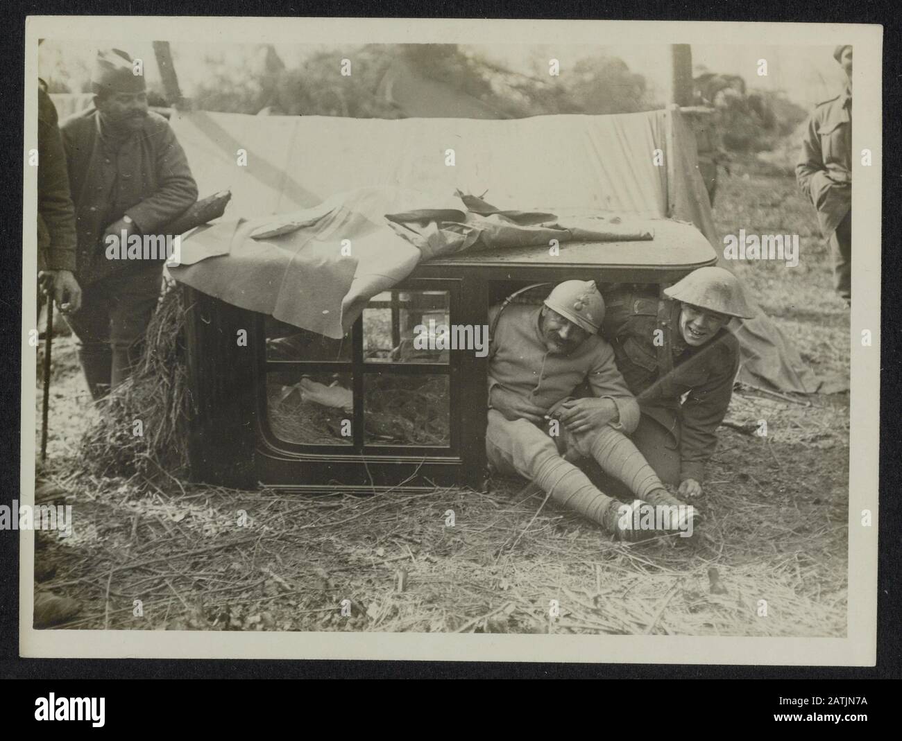 The British Western Front in France Description: The German offensive. A British and French soldier bivouaced under the top of a motor car in a French wood Annotation: British Western Front in France. The German offensive. British and French soldiers camped under the cab of a truck Date: {1914-1918} Location: France Keywords: woods, First World War, fronts, soldiers, trucks Stock Photo