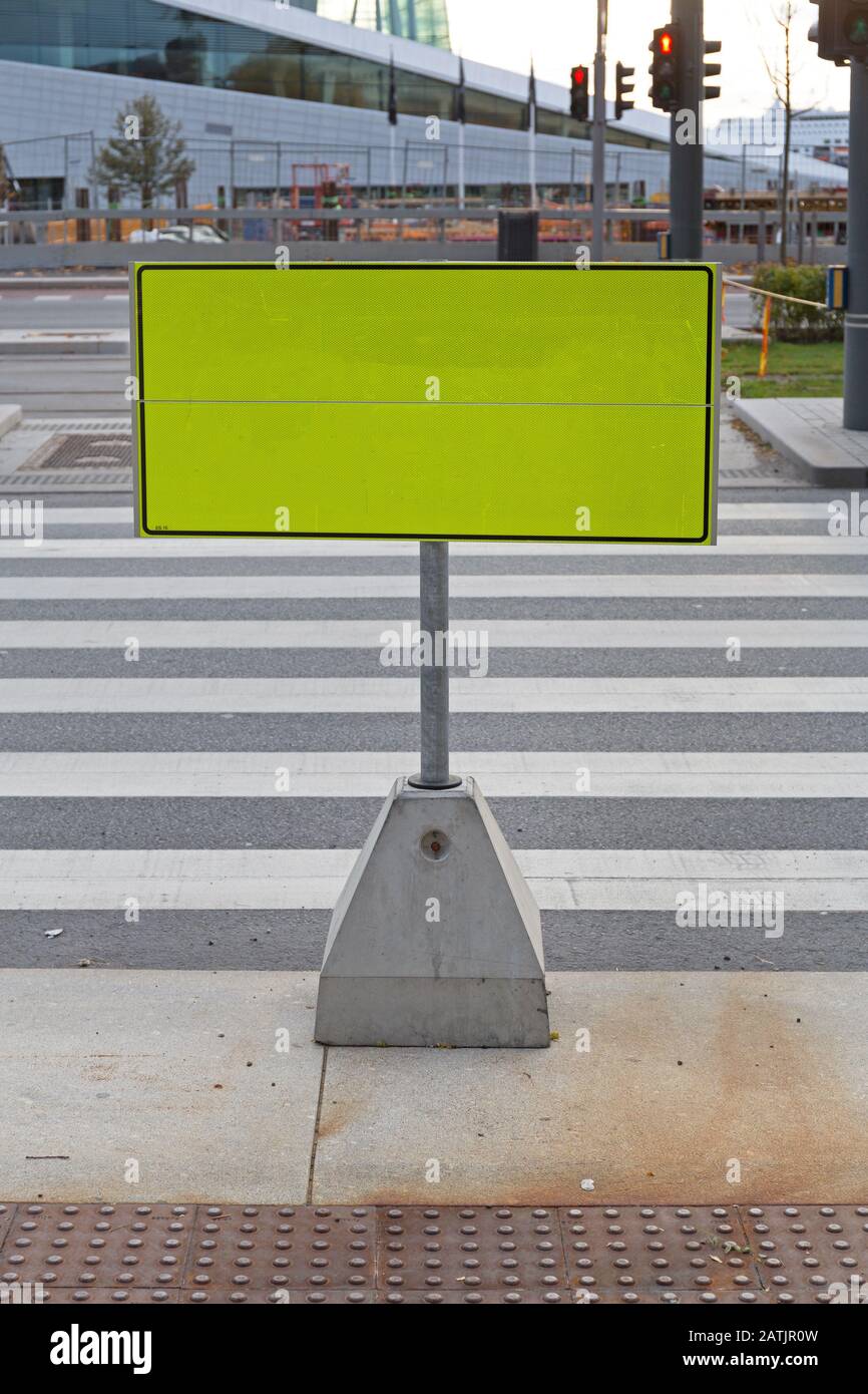 Big Yellow Caution SIgn Board at Street Crossing Stock Photo