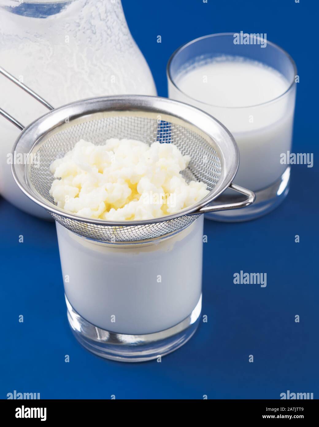 Kefer Homemade fermented beverage kefir with kefir graiuns on a trendy blue ...