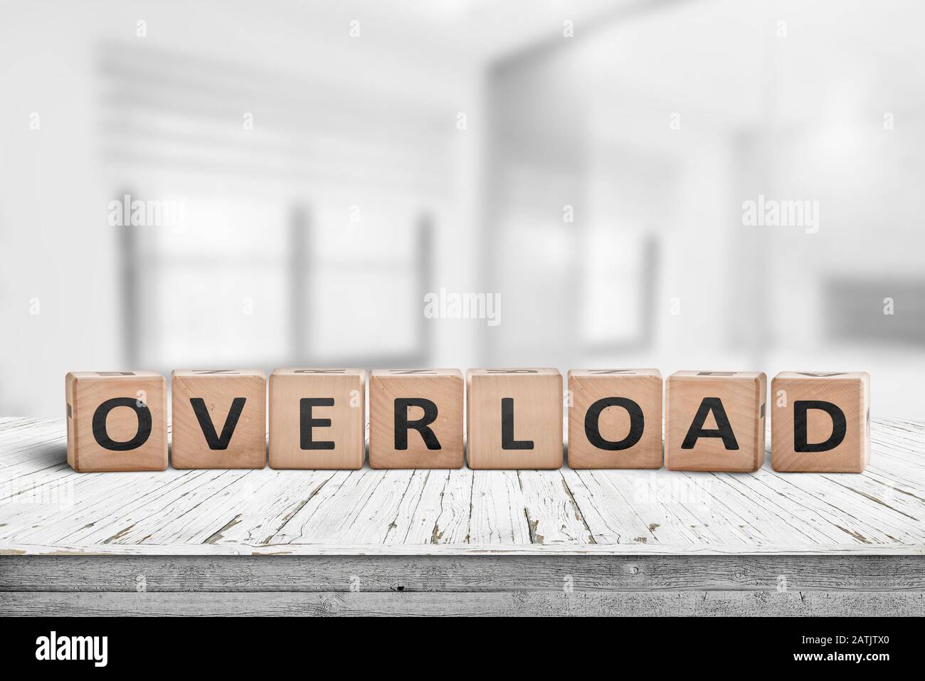 Sign with the word overload in a bright office environment on a wooden table Stock Photo