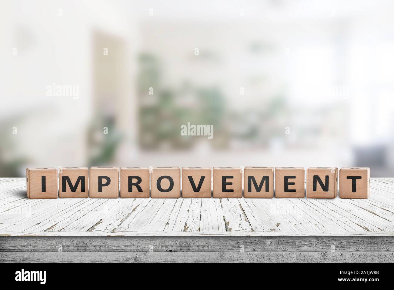 Improvement sign on a wooden office desk in a bright room with green colors Stock Photo