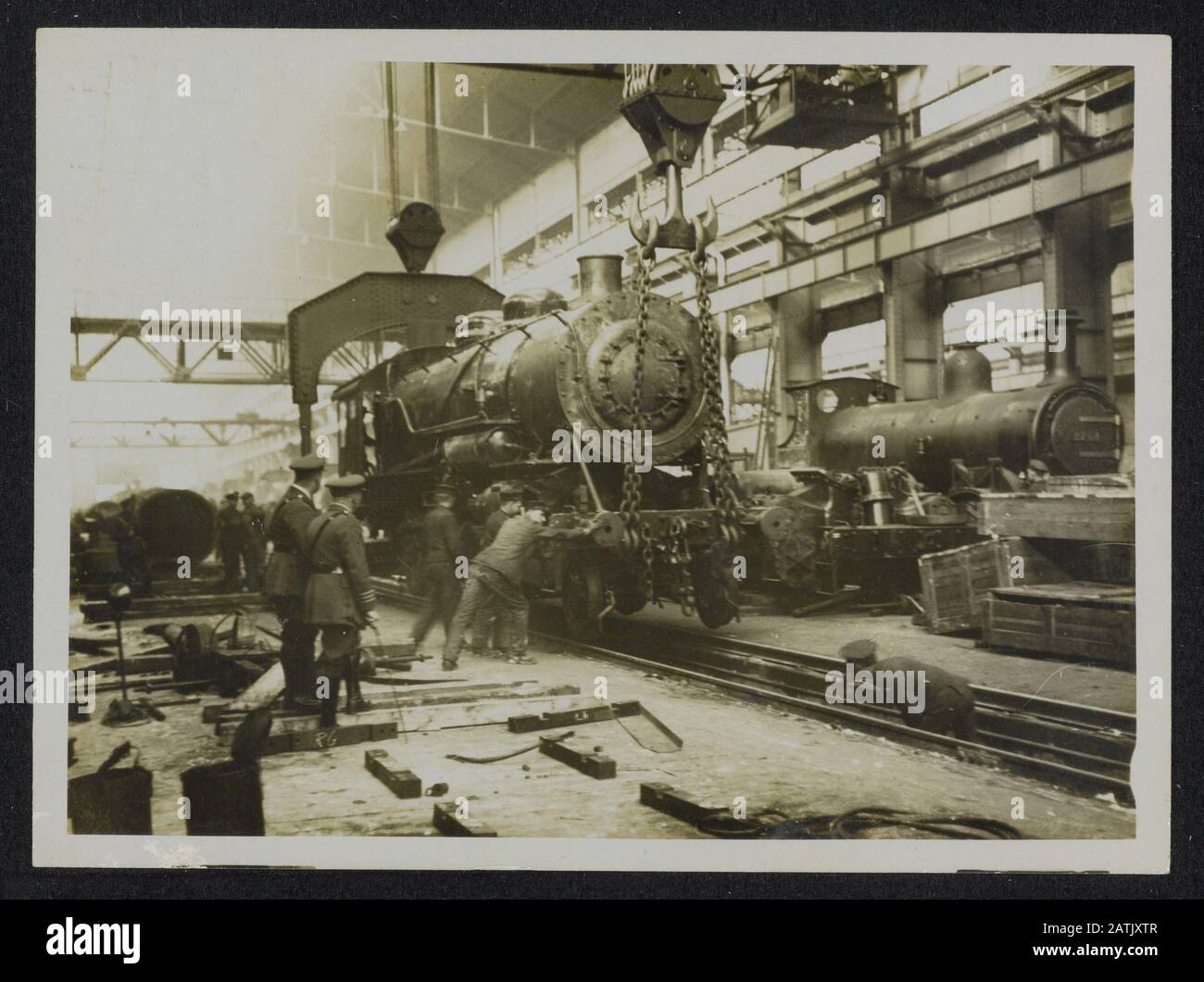 The British Western Front in France Description: British Railway work in France. In our Loco shops in France. Hoisting a 60 ton engine on to the rails Annotation: British Western Front in France. British railway workers in France. The locomotive workshops in France. A 60 ton machine on track hoisted Date: {1914-1918} Location: France Keywords: WWI, fronts, locomotives, railways, workshops Stock Photo