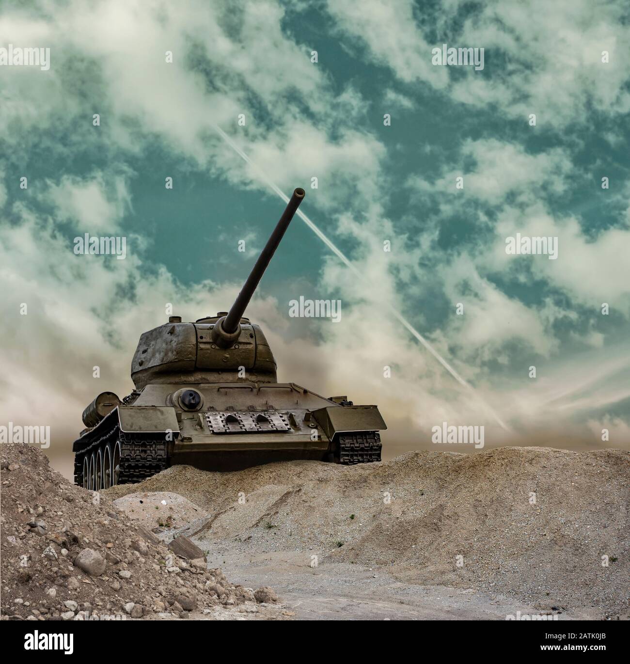 A tank front side approaching and aiming on a dramatic cloudy summer sky background Stock Photo