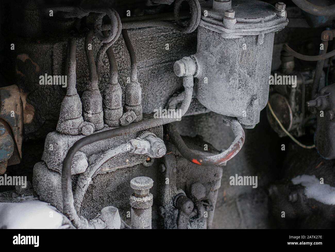 A frozen diesel engine of a truck, bus or a vintage tractor on a cold