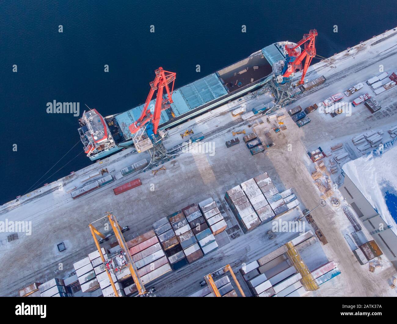 Commercial north arctic port is loading containers onto cargo tanker ship. Concept logistics and delivery of goods Stock Photo